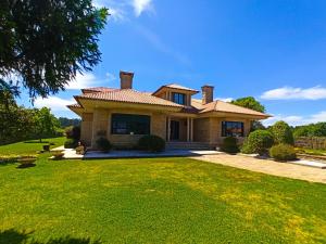 a house with a green lawn in front of it at Villa Remoan in Vilagarcia de Arousa