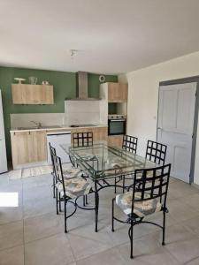 una cucina con tavolo in vetro e sedie di chez Robert a Bromont-Lamothe