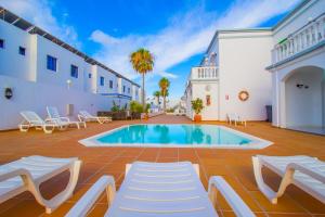 a villa with a swimming pool in a courtyard at Apartamentos Corona Mar in Puerto del Carmen