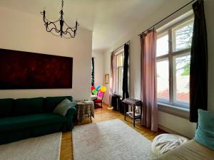 a living room with a green couch and a window at ApartmentVillaSolomon7 in Visegrád