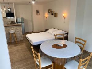 um quarto com uma mesa e uma cama e uma cozinha em Appartement résidence vacances amandier em Arles