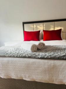 a bed with red pillows and two towels on it at Modern Luxury 3 bedroom house in Durban