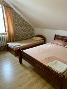 een slaapkamer met 2 bedden en een raam bij Гостиный Дом Comfort in Reni