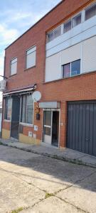 a brick building with a garage on a street at Sol Poniente in La Fregeneda