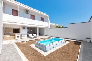 a swimming pool in the backyard of a house at Villa delle Mimose by BarbarHouse in San Foca