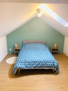 1 dormitorio con 1 cama con edredón azul en La Valencianne, en Valenciennes