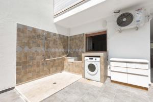 een badkamer met een douche en een wasmachine bij Villa delle Mimose by BarbarHouse in San Foca