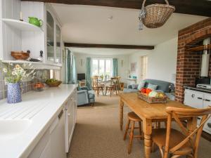 a kitchen with a table with a basket of fruit on it at Lower Woodend Cottage in Ludlow