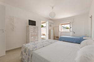 a white bedroom with two beds and a tv at Villa delle Mimose by BarbarHouse in San Foca