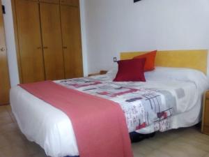 a bedroom with a large white bed with red pillows at Apartamento 1ª línea de playa!!! in Cambrils