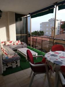 a room with a balcony with a table and chairs at Apartamento 1ª línea de playa!!! in Cambrils