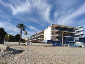 a building on the beach with palm trees in front of it at Apartamento 1ª línea de playa!!! in Cambrils