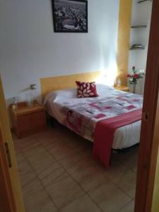 a bedroom with a bed with a red and white blanket at Apartamento 1ª línea de playa!!! in Cambrils