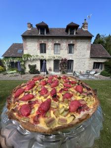 une grande pizza sur une table devant une maison dans l'établissement La Maison d'Aline - Honfleur - Maison d'Hôte De Charme A La Normande, à Honfleur