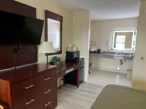 a bedroom with a dresser and a desk with a television at Surry Inn - Dobson in Dobson