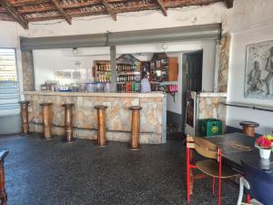 a bar with wooden stools in a room at Downtown Virgins Hotel in Elmina