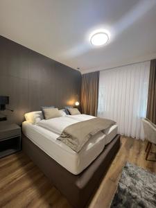 ein Schlafzimmer mit einem großen Bett in einem Zimmer in der Unterkunft Hotel Harmshof Bispingen in Bispingen