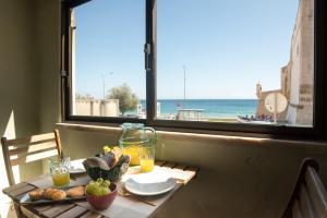 a table with a view of the beach from a window at Apartamento Fortaleza in Sesimbra