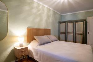 a bedroom with a bed and a night stand with a lamp at Apartamento Fortaleza in Sesimbra