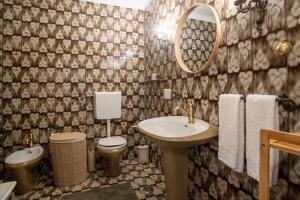 a bathroom with a sink and a toilet and a mirror at Apartamento Fortaleza in Sesimbra