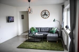 sala de estar con sofá y reloj en la pared en Zweite Heimat Nürburg, en Reimerath
