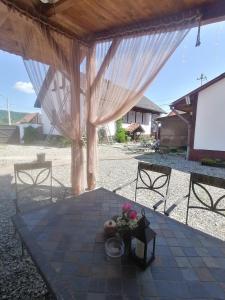 Un patio cubierto con una mesa con flores. en Casa Huber, en Cîrţa
