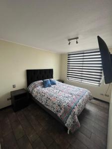a bedroom with a bed and a television in it at Elegante departamento in Iquique