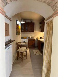 a kitchen with an archway with a table and a chair at Costa del sole 42 in Cetona