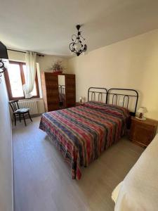 Schlafzimmer mit einem Bett und einem Kronleuchter in der Unterkunft Costa del sole 42 in Cetona