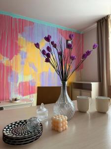Eine Vase mit lila Blumen auf dem Tisch in der Unterkunft STENATA Sport Apartments in Pamporowo
