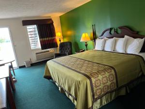 a hotel room with a bed and a green wall at Surry Inn - Dobson in Dobson