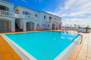 a large swimming pool in front of a house at Apartamentos Corona Mar in Puerto del Carmen