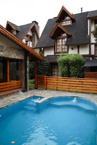 a swimming pool in front of a house at Cabañas Woodland in San Martín de los Andes