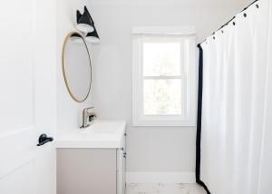 a bathroom with a sink and a mirror and a window at Tranquil River Home in Asheville +18 photos