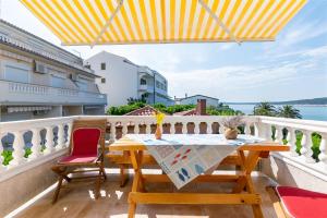 una mesa y sillas en un balcón con vistas al océano en Apartments Biserka en Barbat na Rabu