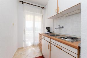 eine Küche mit einer Spüle und einer Arbeitsplatte in der Unterkunft Apartments Biserka in Barbat na Rabu