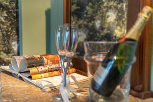 una botella de vino sentada en una mesa con copas en Villa Sophia by ALMA Holiday Rentals, en Caniço