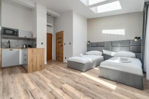 a bedroom with two twin beds and a kitchen at Toress Apartamenty plac Grunwaldzki in Szczecin