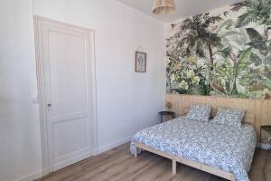 1 dormitorio con 1 cama y un mural en la pared en Relaxing Holiday Home YHH, en Lacanau