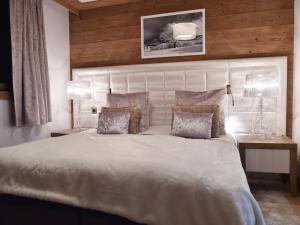 a bedroom with a large white bed with two lamps at Appartement Courchevel 1550, 2 pièces, 4 personnes - FR-1-562-52 in Courchevel