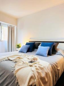 a bedroom with a large bed with blue pillows at El mejor Dpto en Nva Cordoba al alcance de todo!! in Cordoba