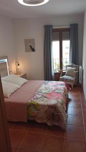 um quarto com uma cama, uma cadeira e uma janela em Apartamento rural Ca La Rumbeta en La Fresneda em La Fresneda