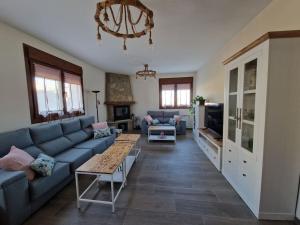 a living room with a blue couch and a tv at Casa Rural Villa Cárcavas in Maello