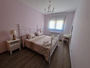 a white bedroom with a bed and a window at Casa Rural Villa Cárcavas in Maello