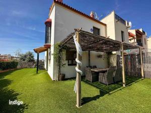 a backyard with a pergola and a table and chairs at Bright Refurbished 3 Bedroom Townhouse ALI001 in Ayamonte