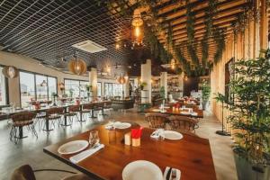a restaurant with wooden tables and chairs and a large room at Caesar resort & SPA, Claudius 2 bedroom apartment, Iskele, Long beach in Saint Yeorgios