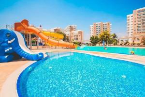 a pool with a water slide in a resort at Caesar resort & SPA, Claudius 2 bedroom apartment, Iskele, Long beach in Saint Yeorgios