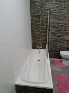 a white bath tub in a bathroom with a toilet at 4 Bedroom House at Saint julians in St. Julianʼs