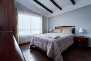 ein Schlafzimmer mit einem großen Bett und einem Fenster in der Unterkunft Villas de Yanahuara in Ollantaytambo