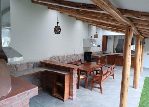 uma sala de jantar com uma mesa de madeira e cadeiras em Villas de Yanahuara em Ollantaytambo